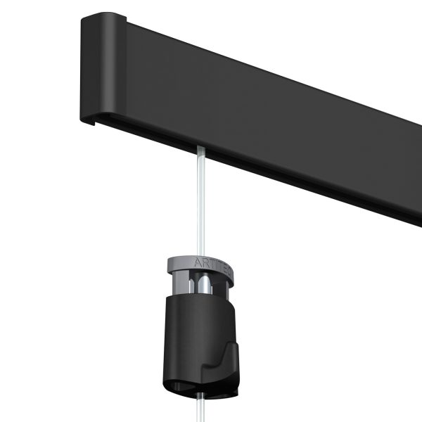 Close-up of a black ceiling-mounted track with a hanging cord and a grey connector clamp securing a light fixture (ARTTEC).