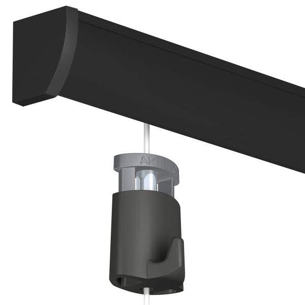 Close-up of a cylindrical pendant light attached to a white cord hanging from a black ceiling beam, showing the silver mounting collar.